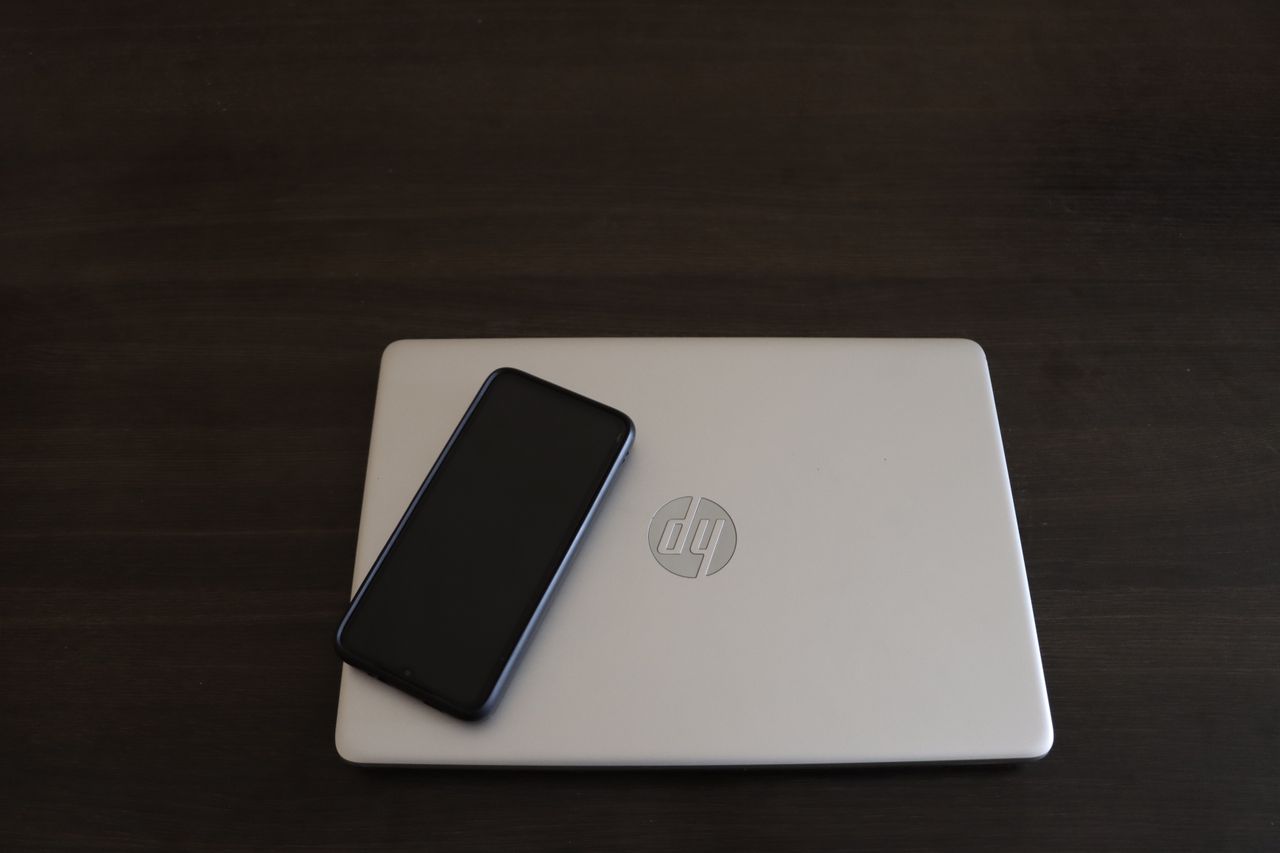 Crafting Captivating Headlines: Your awesome post title goes here Close-up of a smartphone resting on an HP laptop, symbolizing modern technology integration.