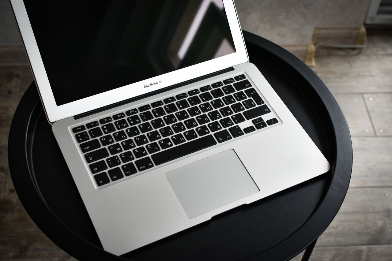 Services A stylish laptop sits elegantly on a black round table in an indoor setting, ideal for tech and workspace themes.