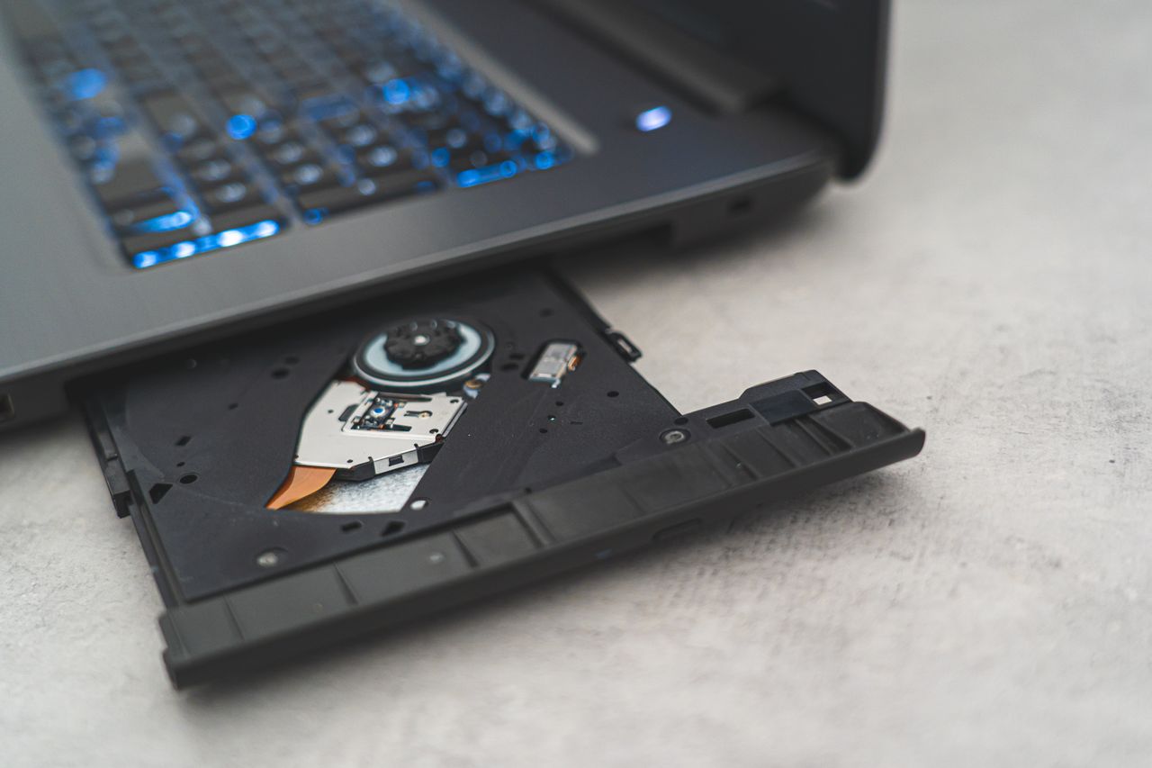 Mastering the First Impression: Your intriguing post title goes here Modern laptop showing open CD drive, highlighting optical disk technology.